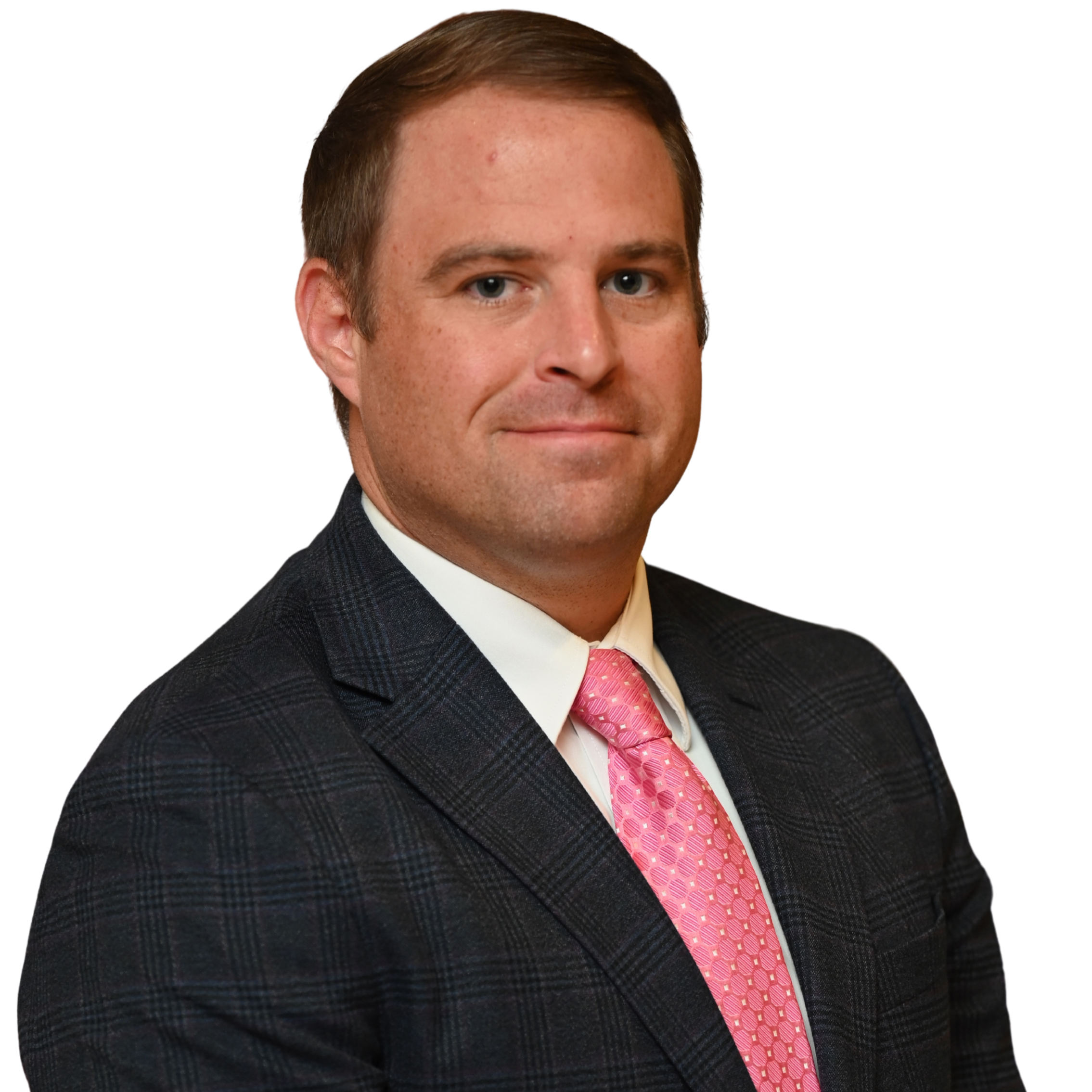 A man in a dark plaid suit, white shirt, and pink tie poses for a professional headshot against a plain white background. He has short brown hair and a neutral expression.